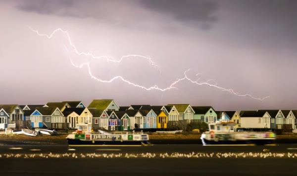 Lightning strikes over beach huts